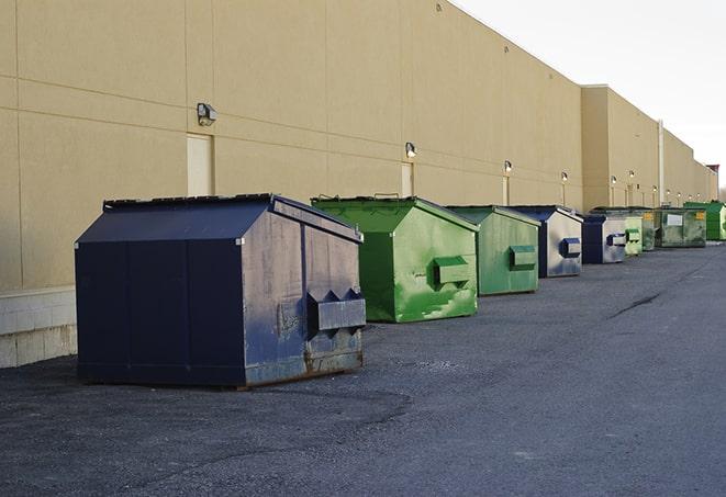 a construction worker moves construction materials near a dumpster in Arp